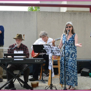 A photo of the five-person band, the Driftless Regionaires, performing outdoors.
