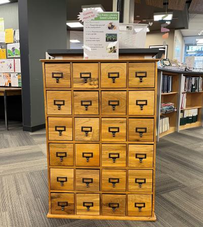 Sequoya's seed cabinet, in the style of a card catalog, with a "coming March 1st" sign on top