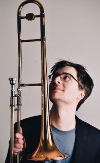 Photo of Max Brown holding and looking up at his trombone