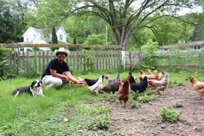 Naturalist-in-Residence Alex Booker, on his farm with his chickens