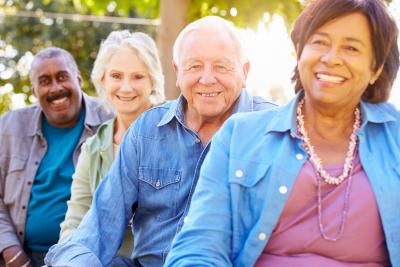 Four older adults sitting and smiling at the camera