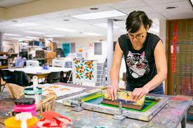 artist pulling ink across a screen