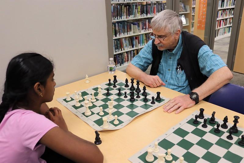 A photo of an adult and a youth playing chess at Meadowridge Library
